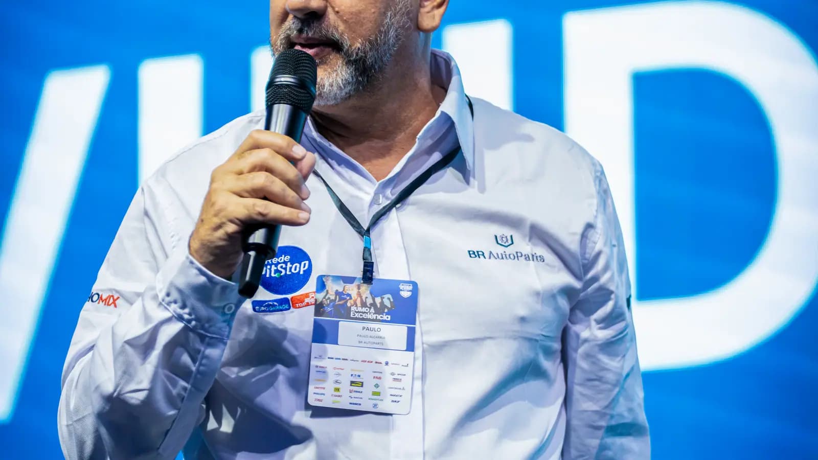 Palestrante com microfone no palco da convenção de vendas