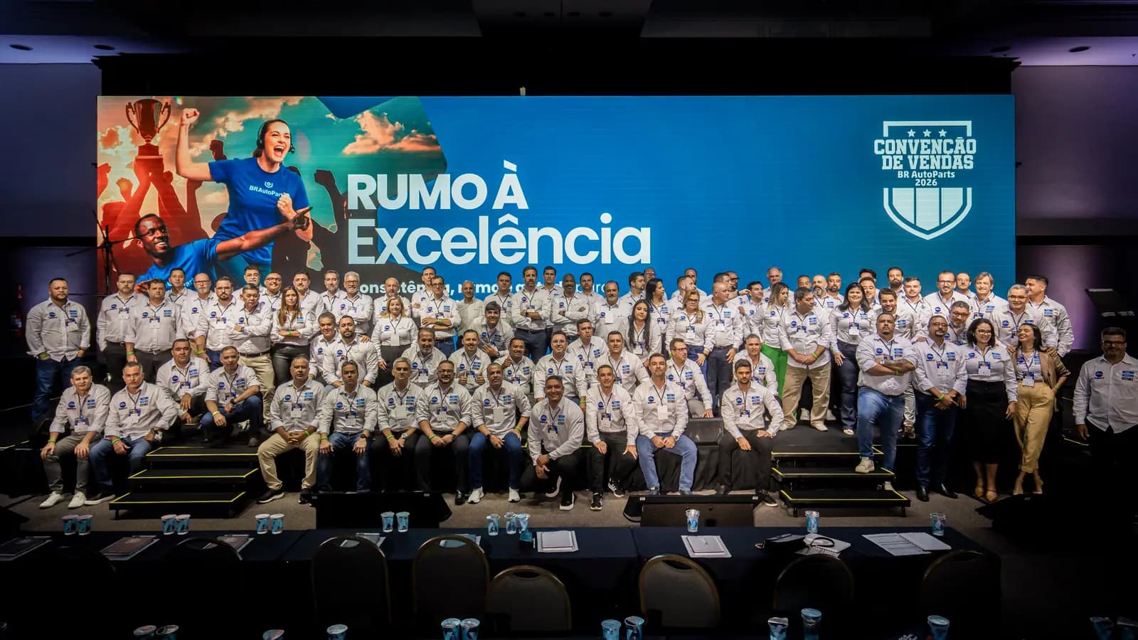 Foto oficial da equipe reunida no palco da convenção de vendas