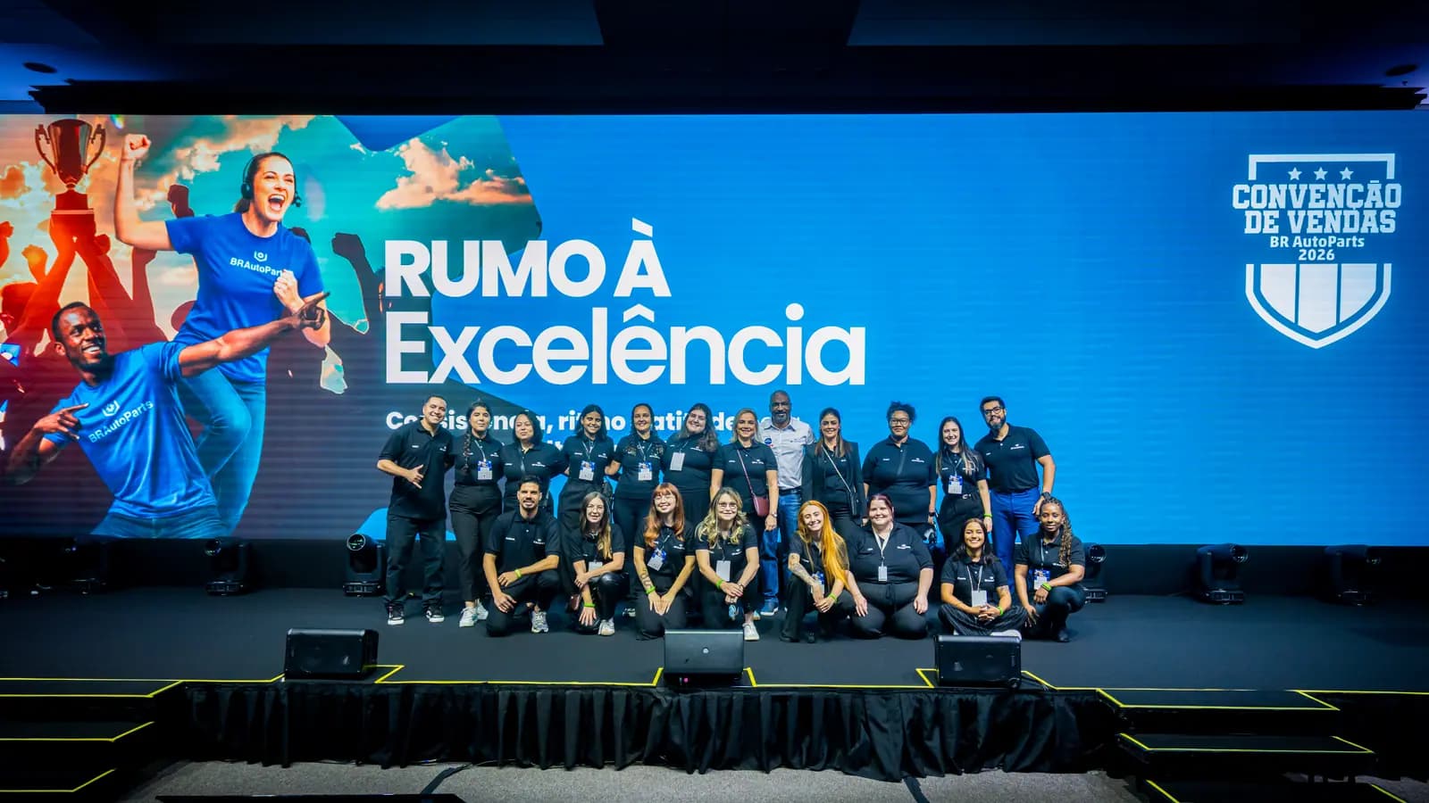 Foto oficial da equipe reunida no palco da convenção de vendas