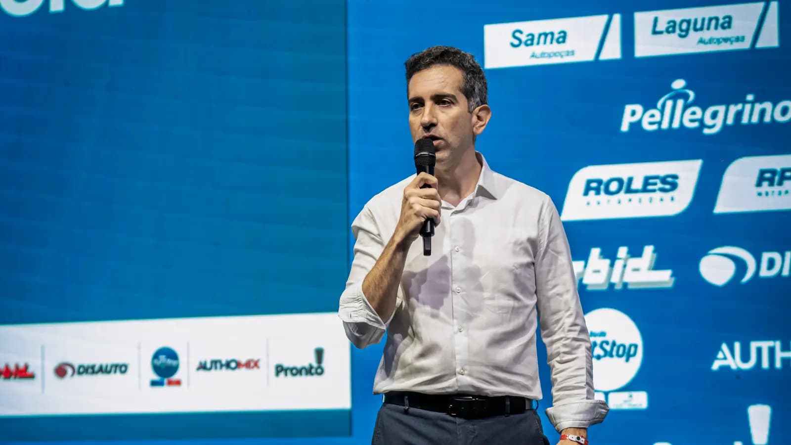 Palestrante com microfone no palco da convenção de vendas