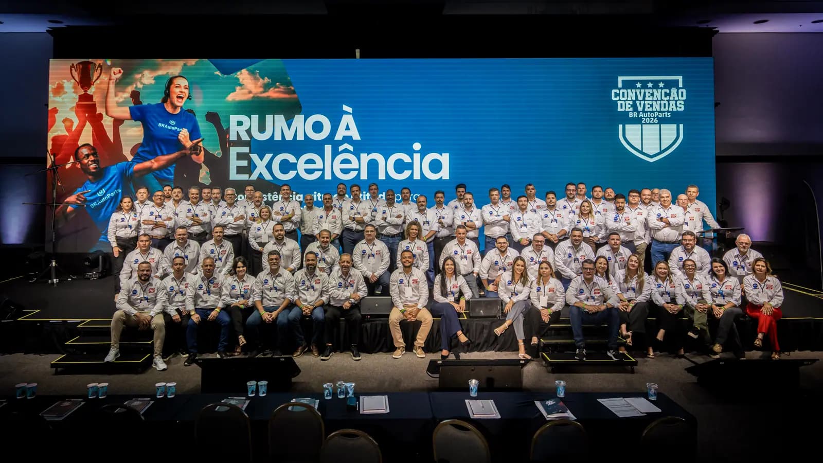 Foto oficial da equipe reunida no palco da convenção de vendas