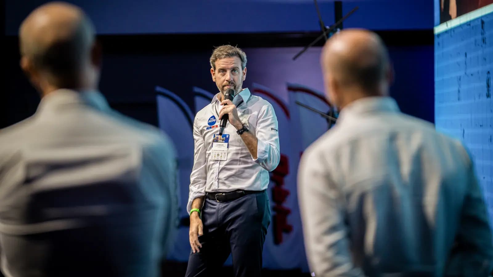 Palestrante com microfone entre os participantes da convenção de vendas