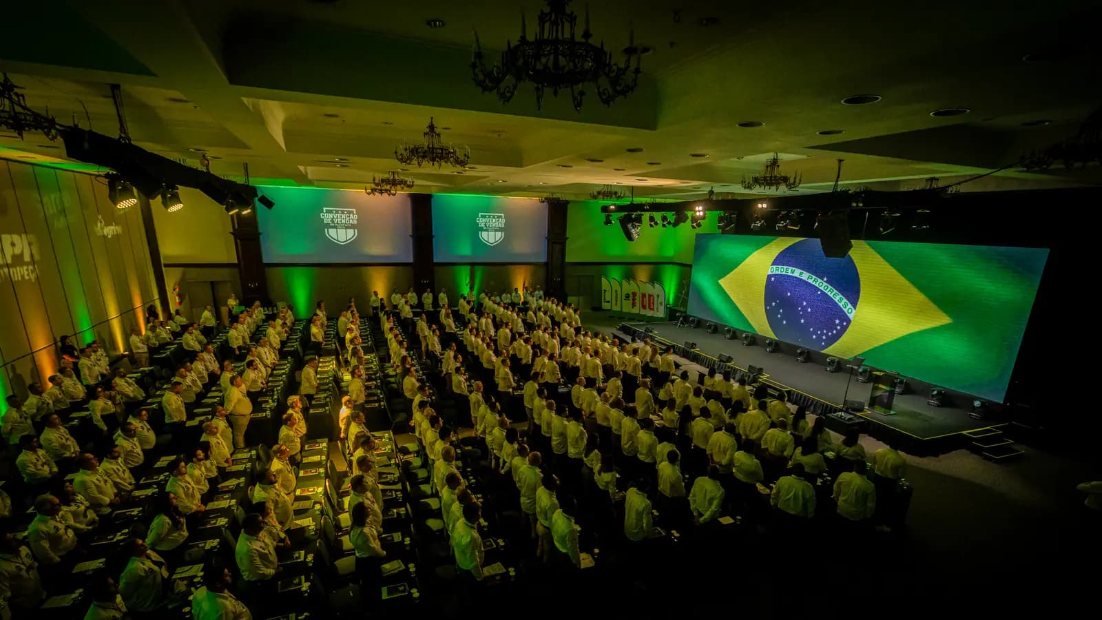Plateia da convenção com a bandeira do Brasil no telão