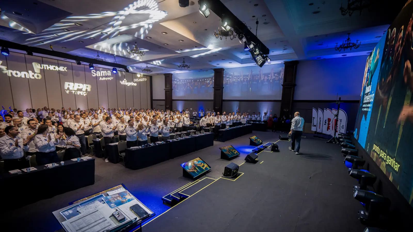 Palco e plateia da convenção de vendas com iluminação cênica azul