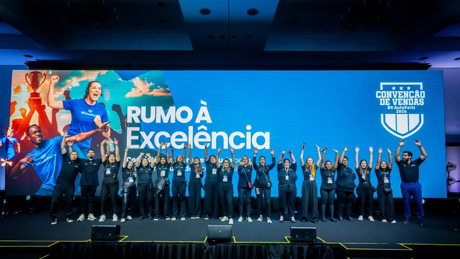 Equipe comemorando no palco durante a convenção de vendas